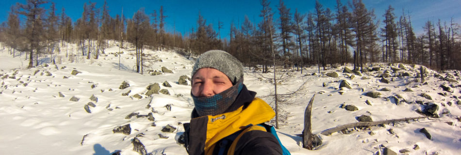Алексей Забелин на фоне заснеженных камней на склоне Большого Саранакана